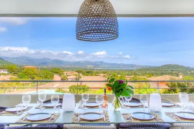 a dining table with a view of the mountains at alba in Pinarellu