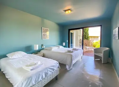 two beds in a room with a view of a patio at alba in Pinarellu