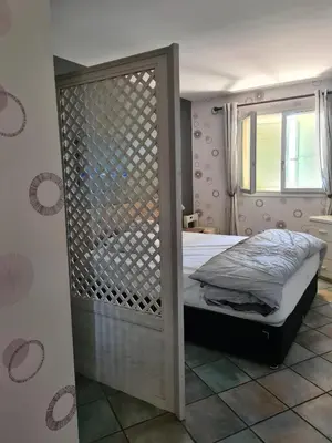 a bedroom with a bed with a wooden frame at la grande piscine in Porto-Vecchio