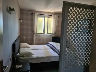a small bedroom with a bed and a window at la grande piscine in Porto-Vecchio