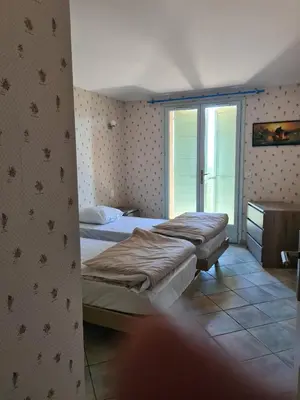 a bedroom with two beds in a room with a window at la grande piscine in Porto-Vecchio