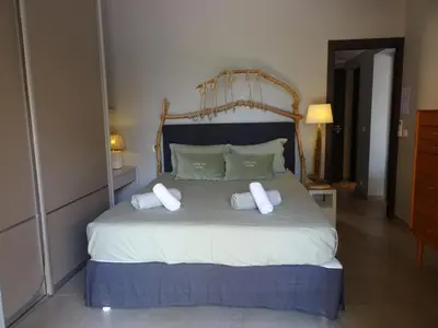 a bedroom with a large bed with towels on it at Les Voiles in Pinarellu
