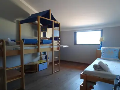 a dorm room with a bunk bed and a bed and a bunk bed at Les Voiles in Pinarellu