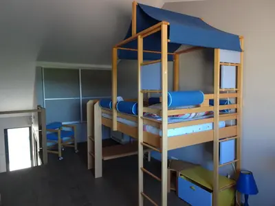 a bunk bed in a room with blue bunk beds at Les Voiles in Pinarellu