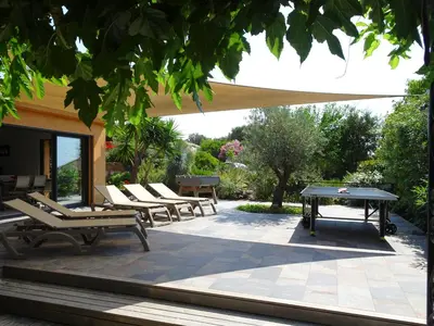 a patio with chairs and a ping pong table at Les Voiles in Pinarellu