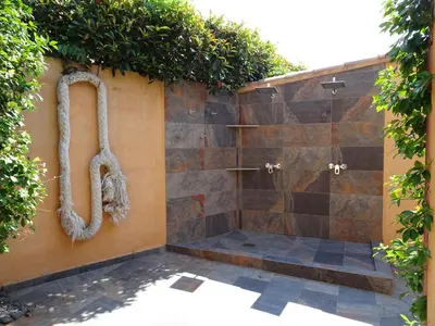 a shower with a hose attached to a wall at Les Voiles in Pinarellu