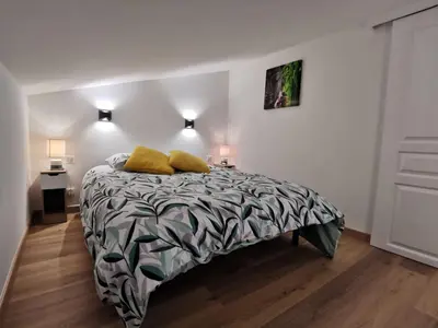 a bedroom with a bed with a black and white comforter at Agréable T2 proche Porto Vecchio in Sotta