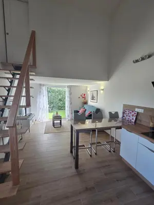 a living room with a staircase and a table at Agréable T2 proche Porto Vecchio in Sotta