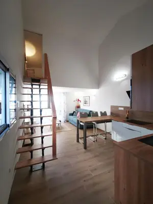 a living room with a staircase and a table at Agréable T2 proche Porto Vecchio in Sotta