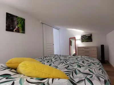 a bedroom with a bed with a yellow pillow on it at Agréable T2 proche Porto Vecchio in Sotta