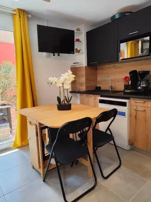 a kitchen with a wooden table and two chairs at T2 Cyprien, Climatisé, piscines, resto, Plages 2-4 pers in Lecci