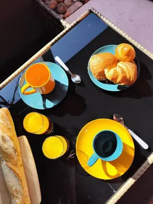 a table with plates of bread and cups of coffee at T2 Cyprien, Climatisé, piscines, resto, Plages 2-4 pers in Lecci