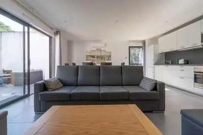 a living room with a couch and a kitchen at La Plage d'Argent - Vue mer et montagne in Coti-Chiavari