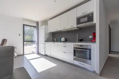 a kitchen with white cabinets and a microwave at La Plage d'Argent - Vue mer et montagne in Coti-Chiavari