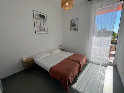 a bedroom with a bed and a large window at Bel appartement avec piscine en bord de mer in Ajaccio
