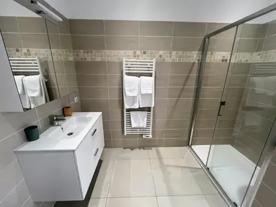 a bathroom with a shower and a sink and a mirror at Bel appartement avec piscine en bord de mer in Ajaccio