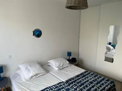 a bed with two pillows in a white room at Accès Direct Mer, Commerces Rivière 15mn in Santa-Lucia-di-Moriani