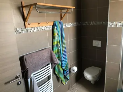 a bathroom with a toilet and a towel at Accès Direct Mer, Commerces Rivière 15mn in Santa-Lucia-di-Moriani