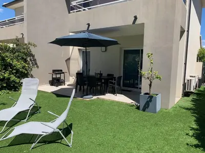 a pair of chairs and an umbrella in a yard at Accès Direct Mer, Commerces Rivière 15mn in Santa-Lucia-di-Moriani