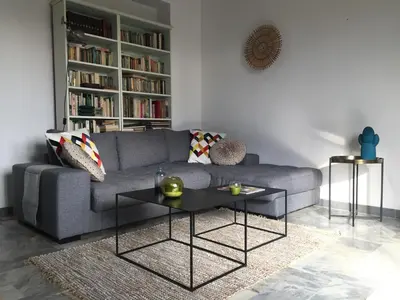 a living room with a gray couch and a table at Location appartement de vacances Ajaccio in Ajaccio