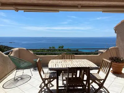 a house with a red roof and the ocean at Maison vue mer Palombaggia in Porto-Vecchio