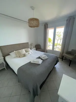 a bedroom with a large bed and a window at Maison vue mer Palombaggia in Porto-Vecchio