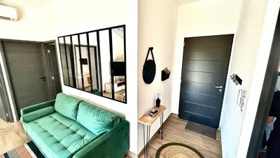 a living room with a green couch and a mirror at havre de paix à Pianottoli proche des plages in Pianottoli-Caldarello