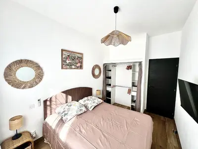 a bedroom with a bed and a mirror at havre de paix à Pianottoli proche des plages in Pianottoli-Caldarello