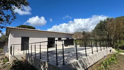 a small white house with a black railing at havre de paix à Pianottoli proche des plages in Pianottoli-Caldarello