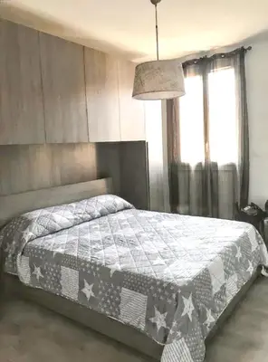 a bedroom with a bed with a gray and white quilt at Appartement à Ajaccio avec vue sur la mer in Ajaccio