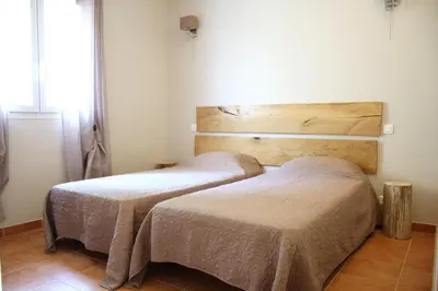 two beds sitting next to each other in a room at Gîte Ortolu in Monacia-dʼAullène