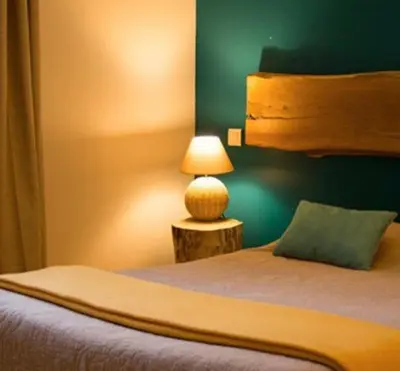 a bedroom with a bed with a lamp on a table at Gîte Ortolu in Monacia-dʼAullène