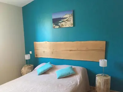 a bedroom with a large bed with blue walls at Gîte Ortolu in Monacia-dʼAullène