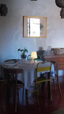 a dining room with a table with chairs and a lamp at Maison de Caractère au coeur du village in Castifao