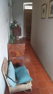 a room with a chair with blue pillows on it at Maison de Caractère au coeur du village in Castifao