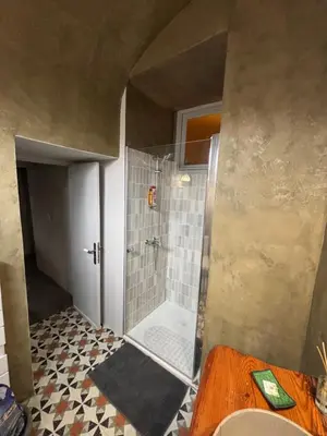 a bathroom with a shower with a tiled floor at Maison de Caractère au coeur du village in Castifao