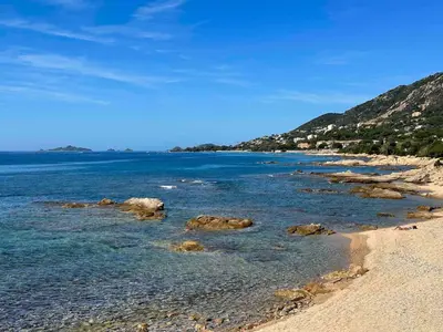 a beach with rocks and the ocean on a clear day at Studio vue mer in Ajaccio