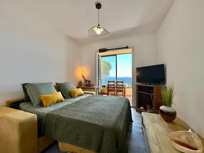 a bedroom with a bed and a television and a table at Studio vue mer in Ajaccio