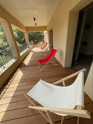 a room with two chairs on a balcony at Maison chaleureuse accès privé à la plage in Olmeto