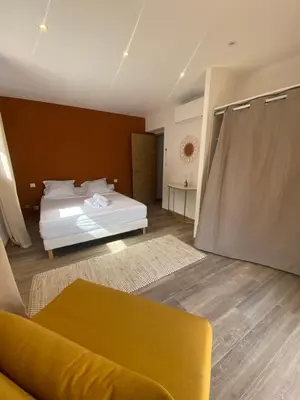 a living room with a bed and a couch at Maison chaleureuse accès privé à la plage in Olmeto