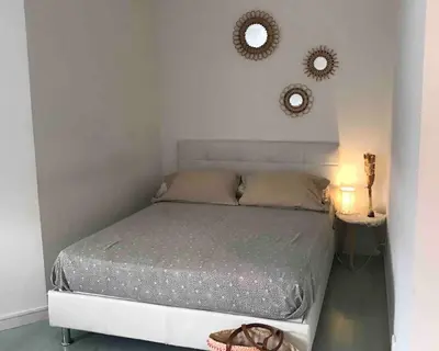 a bedroom with a bed and two mirrors on the wall at Loft Place du Diamant Hyper centre ville Plage 50m in Ajaccio