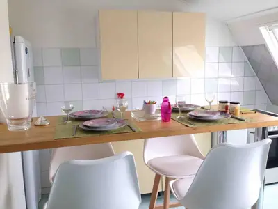 a kitchen with a table with plates and chairs at Loft Place du Diamant Hyper centre ville Plage 50m in Ajaccio