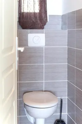 a bathroom with a toilet and a staircase at Le Thyreneen in Sari Solenzara