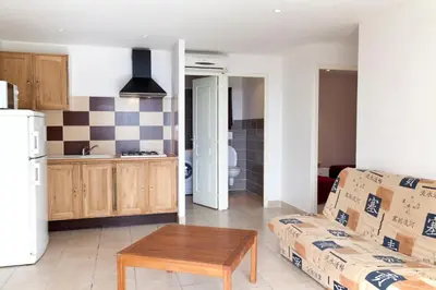 a living room with a couch and a table at Le Thyreneen in Sari Solenzara