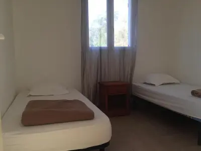 two beds in a room with a window at Le Thyreneen in Sari Solenzara