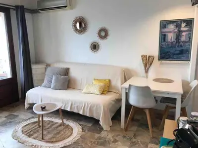 a living room with a couch and a table at Helios grand studio terrasse panoramique magique in Ajaccio