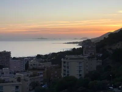 a view of the ocean from a city at sunset at Helios grand studio terrasse panoramique magique in Ajaccio