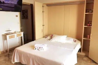 a bedroom with a large white bed with towels on it at Helios grand studio terrasse panoramique magique in Ajaccio