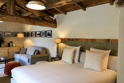 a bedroom with a large bed and a chair at A Mandria di Murtoli in Sartène
