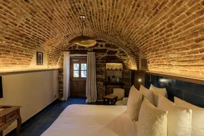 a bedroom with a large bed in a brick wall at A Mandria di Murtoli in Sartène